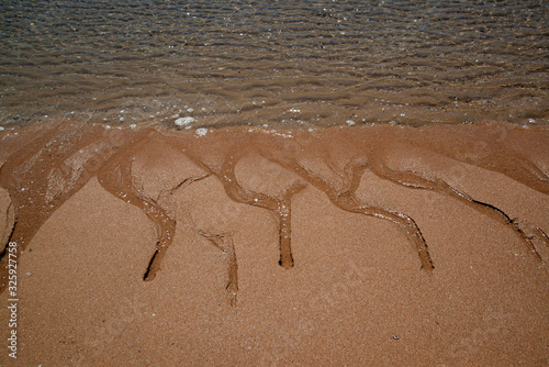 Natural sand patterns in beach at low tide..