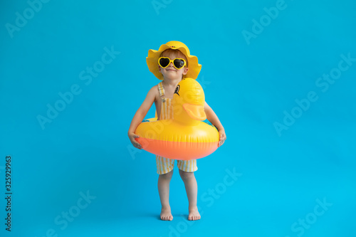 Foto Happy child with yellow rubber duck against blue background