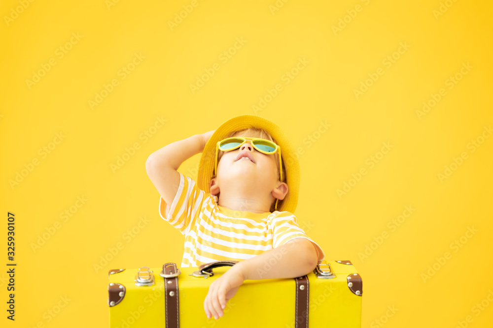 Portrait of happy child with retro yellow suitcase - obrazy, fototapety, plakaty 