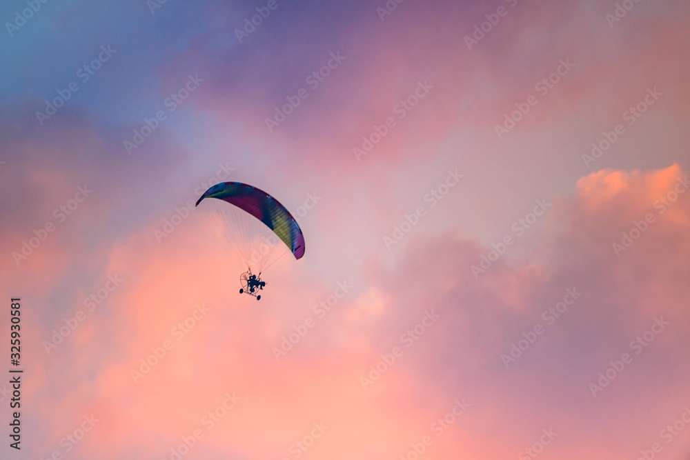 Colorful Paraglider flying against the twilight sky, sunset sky Colorful Paraglider flying against the twilight sky, sunset sky