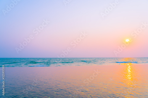 Beautiful tropical nature of sea ocean beach around outdoor swimming pool at sunset or sunrise time