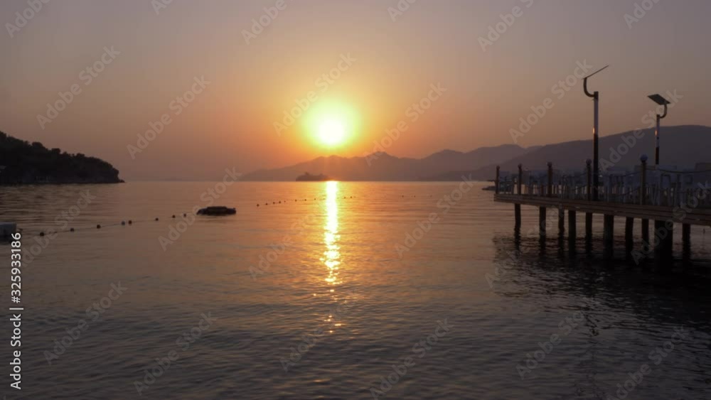 Golden sun and cruise ship floating on mountain silhouette while morning sunrise. Beautiful view bright sunset over sea and mountain. Tourist liner shipping on smooth water on golden sunset landscape Golden sun and cruise ship floating on mountain silhouette while morning sunrise. Beautiful view bright sunset over sea and mountain. Tourist liner shipping on smooth water on golden sunset landscape