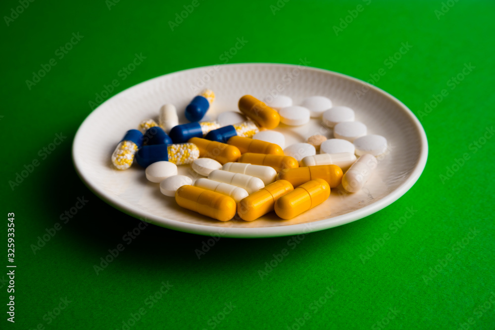 Different tablets, pills, medications drugs on green background Different tablets, pills, medications drugs on green background