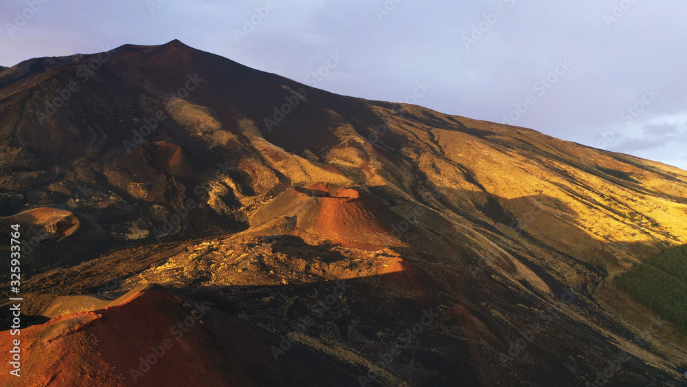 Aerial view of volcanic Silvestri craters of Mount Etna at orange sunset, Catania, Sicily, Italy. Beautiful volcano mountainous valley. National park.