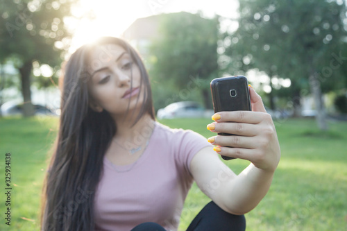 Caucasian woman taking selfie with smartphone.