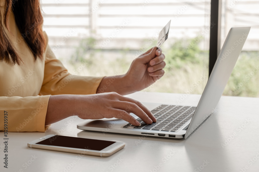 Young lady use credit cards and laptops for online shopping and making payments the internet Young lady use credit cards and laptops for online shopping and making payments the internet