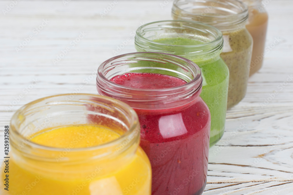 Assortment of jars with tasty baby food on wooden table. vegetable and fruit purees. Assortment of jars with tasty baby food on wooden table. vegetable and fruit purees.