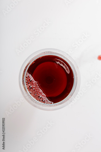 A glass of red wine on a white background. The view from the top