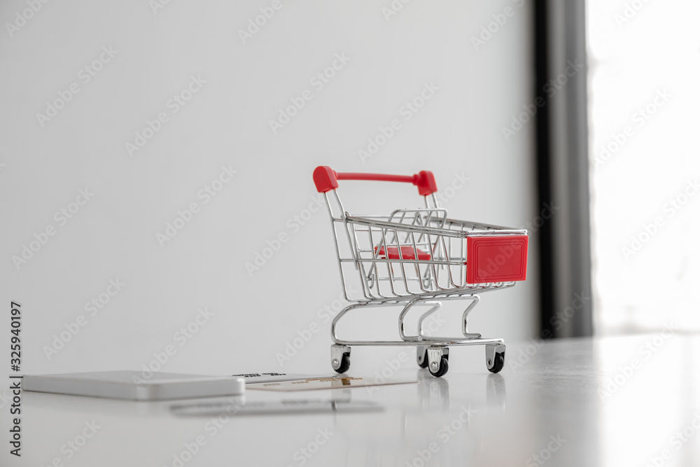 Photos of toys, trolleys, credit cards and smartphones placed on a white table Shopping ideas online