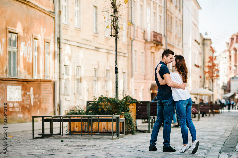 Loving young couple kissing and hugging in st valentine's day at the city. Love and tenderness, dating, romance, family, anniversary concept.
