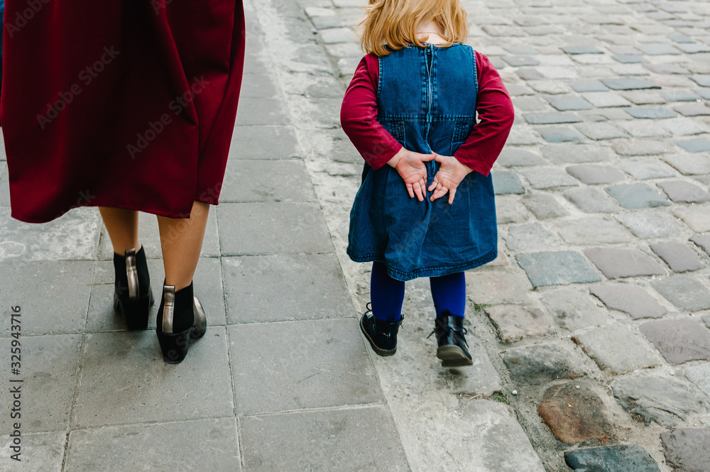 Happy family: mom and daughter enjoying time together, walk on the street city in country Europe. View in the back bottom. Happy family: mom and daughter enjoying time together, walk on the street city in country Europe. View in the back bottom.