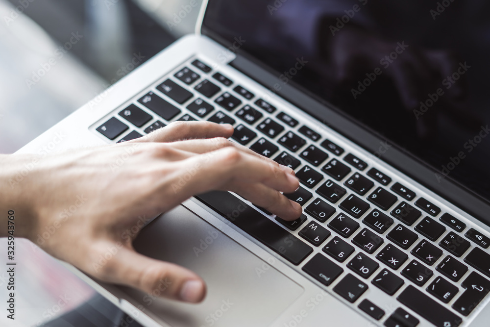 Businessman typing on laptop keyboard in sunny office, business and technology concept. Close up Businessman typing on laptop keyboard in sunny office, business and technology concept. Close up