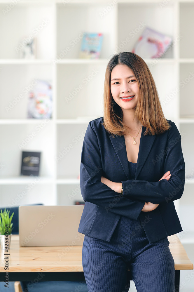 Beautiful businesswoman standing with arms crossed in modern office. Beautiful businesswoman standing with arms crossed in modern office.