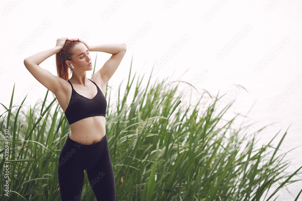 Sports girl. Woman near the river. Lady in a sports wear Sports girl. Woman near the river. Lady in a sports wear