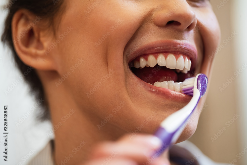 Close-up of a woman brushing teeth with a toothbrush. Close-up of a woman brushing teeth with a toothbrush.