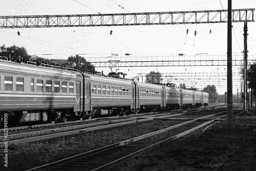 Trains on the railroad. The power line from above is rhythmically repeated. Rails go into perspective.