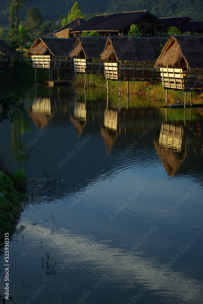 Fototapeta premium In the morning light small huts beside the lake and the mountain view