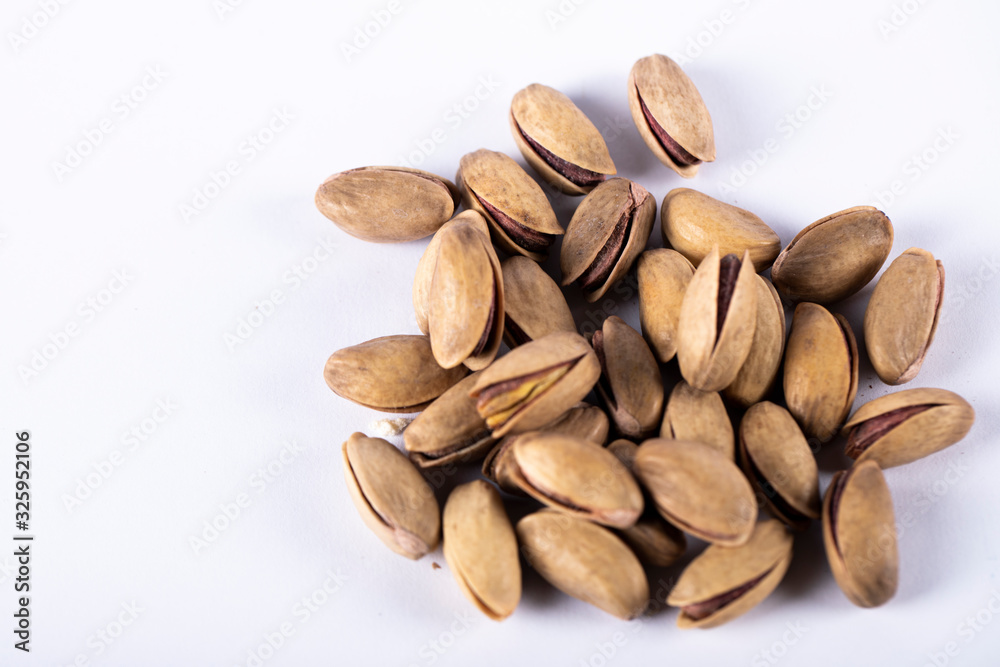 Pistachios isolated on the right side of a white background