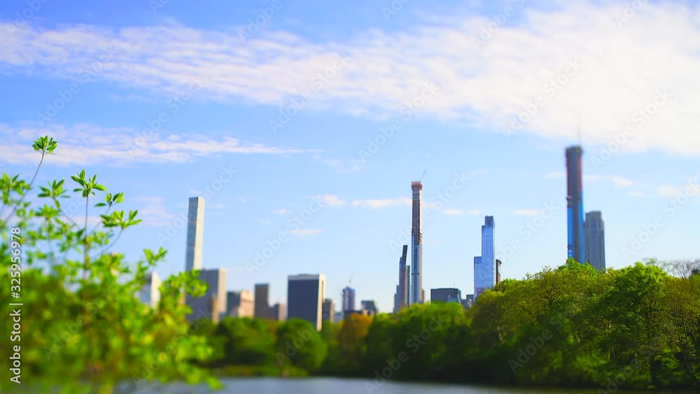 Midtown Manhattan skyscraper stands behind The Lake in the springtime at Central Park at New York City NY USA on May. 06 2019. Midtown Manhattan skyscraper stands behind The Lake in the springtime at Central Park at New York City NY USA on May. 06 2019.