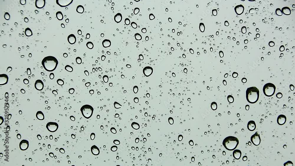 Water drop and Water droplets flow and gather on the glass, On a dark gray backdrop