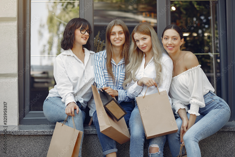 Fototapeta premium Beautiful girls in a summer city. Ladies with shopping bags