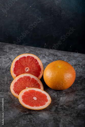 Sliced and whole grapefruit on a black backdrop © azerbaijan-stockers