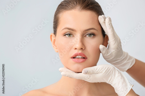 Plastic surgeon touching fa...