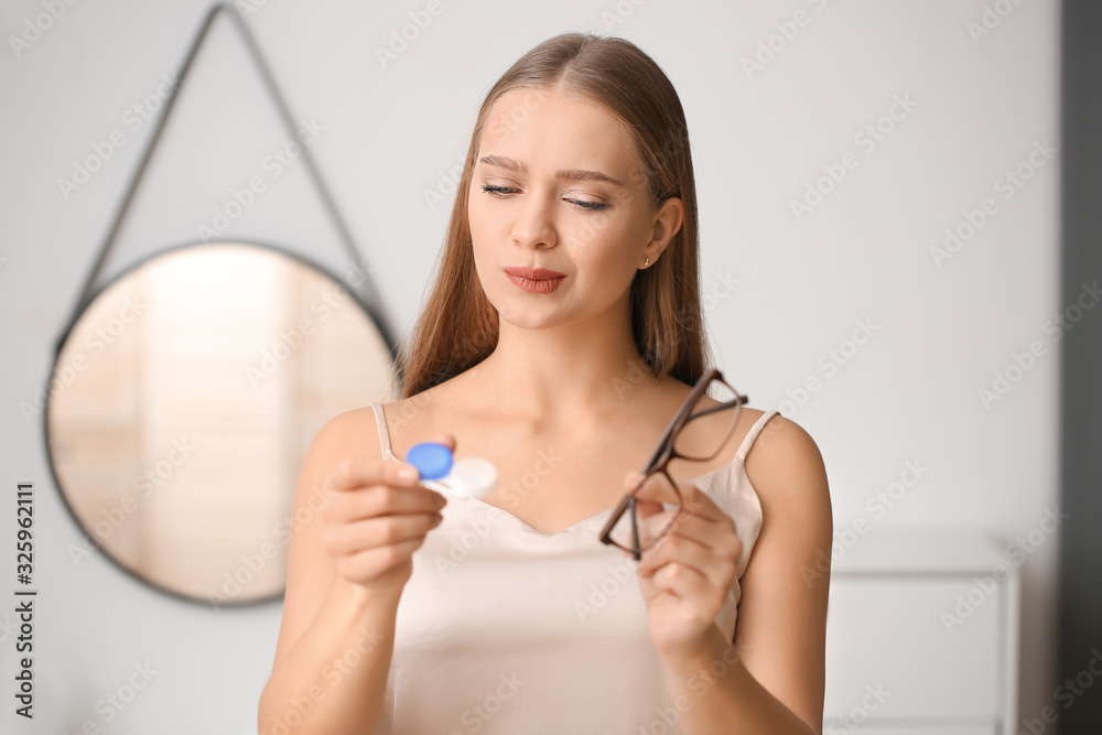 Young woman with contact lens case and eyeglasses at home Young woman with contact lens case and eyeglasses at home