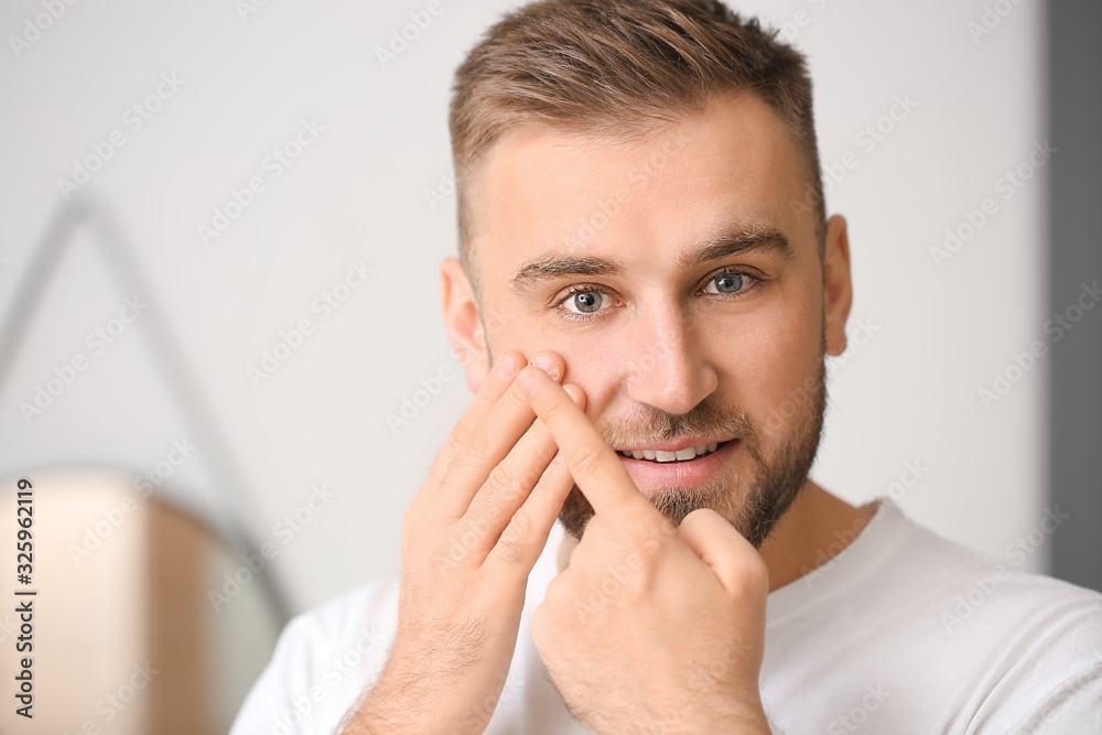Young man putting in contact lenses at home Young man putting in contact lenses at home