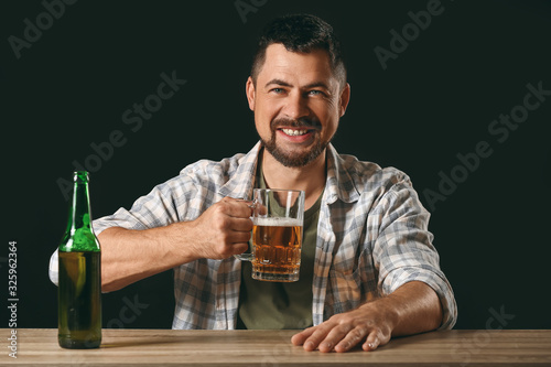 Mature man drinking beer at...