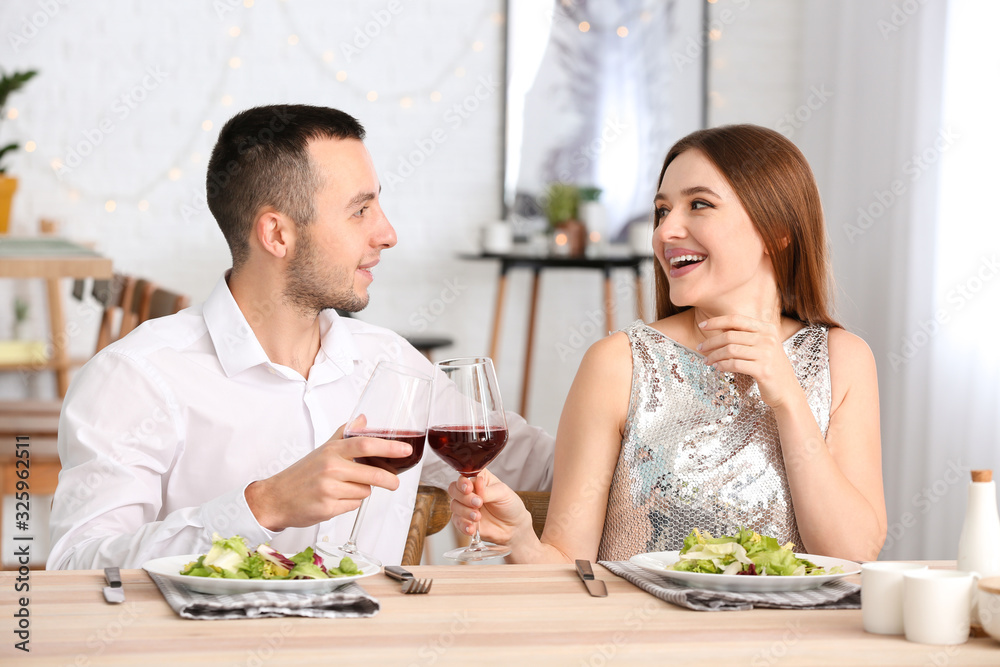 Happy young couple drinking wine on romantic date in cafe