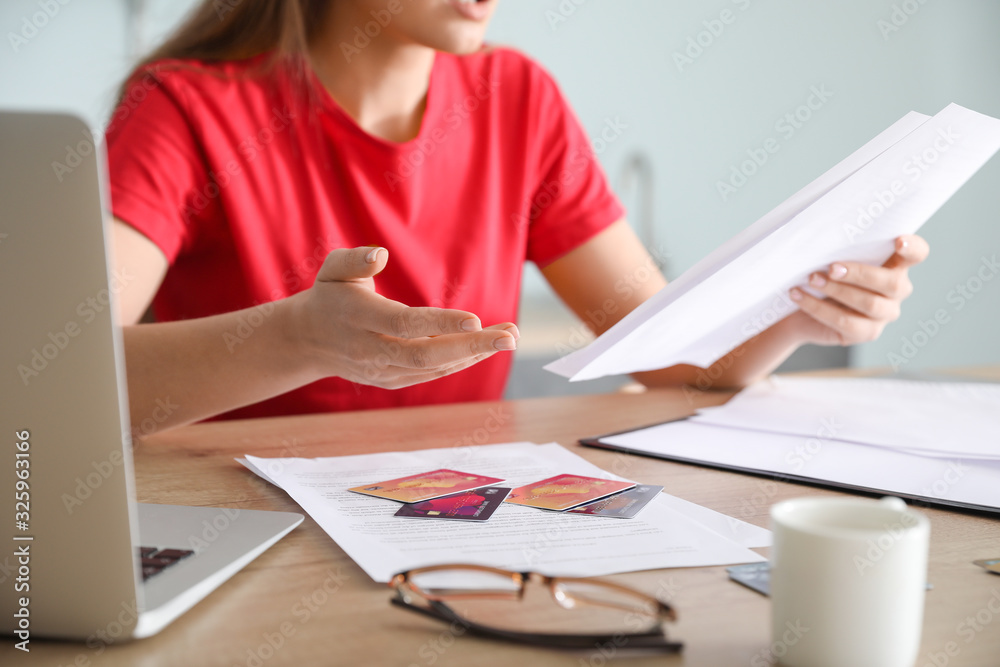 Worried young woman in debt at home Worried young woman in debt at home