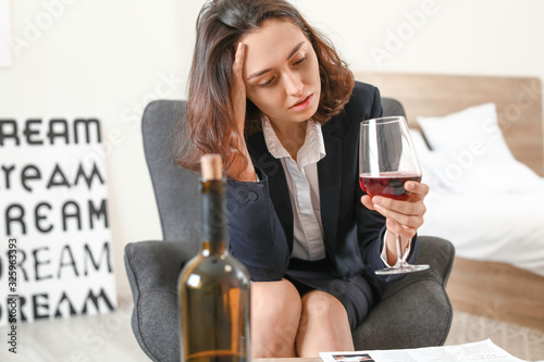 Woman drinking wine at home...