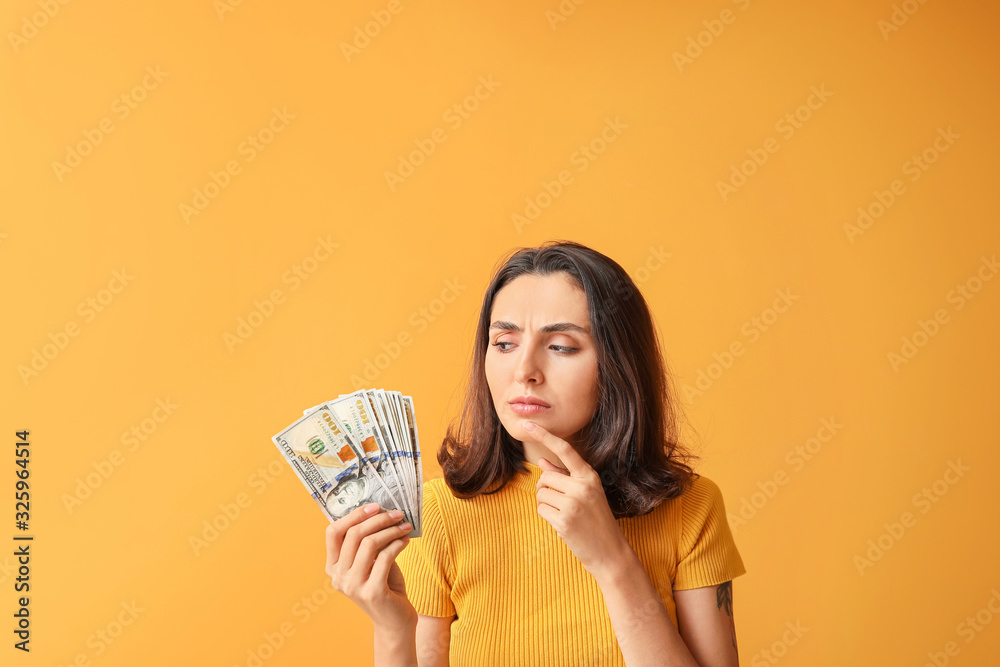 Thoughtful young woman with money on color background Thoughtful young woman with money on color background