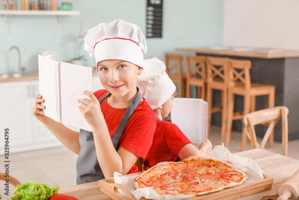Cute little chefs with cook books in kitchen Cute little chefs with cook books in kitchen