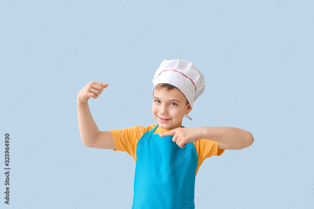 Cute strong little chef on color background Cute strong little chef on color background