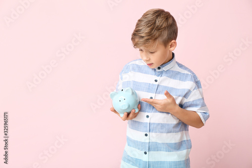 Cute boy with piggy bank on...