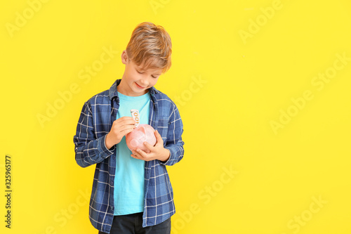 Cute boy putting money in p...