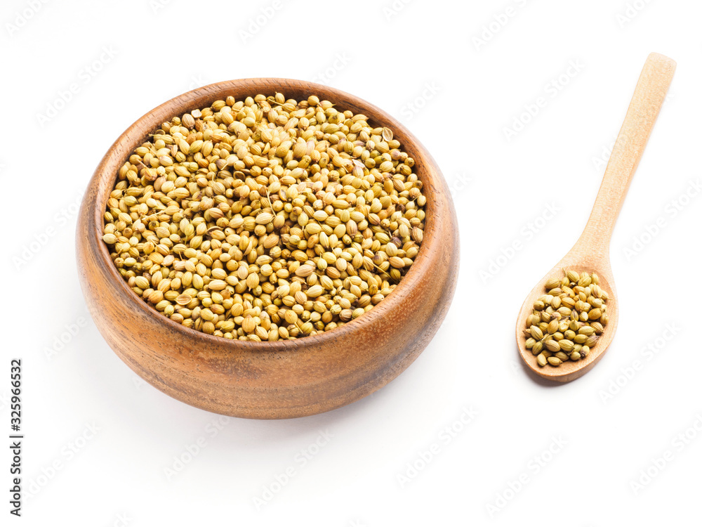 Spice coriander (Coriandrum sativum) seeds in wooden bowl and spoon isolated on white background. Healthy eating concept Spice coriander (Coriandrum sativum) seeds in wooden bowl and spoon isolated on white background. Healthy eating concept