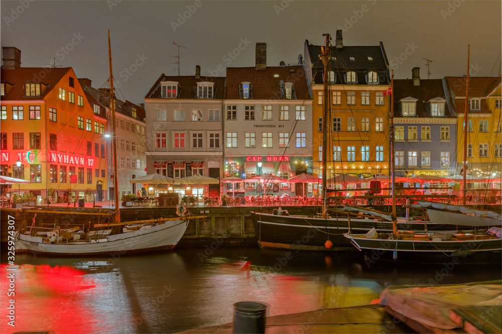 Famous Nyhavn pier with colorful buildings and boats in Denmark, Copenhagen, capital of Denmark. City center and the district of Nyhavn near the canals. Night time, Longexposure