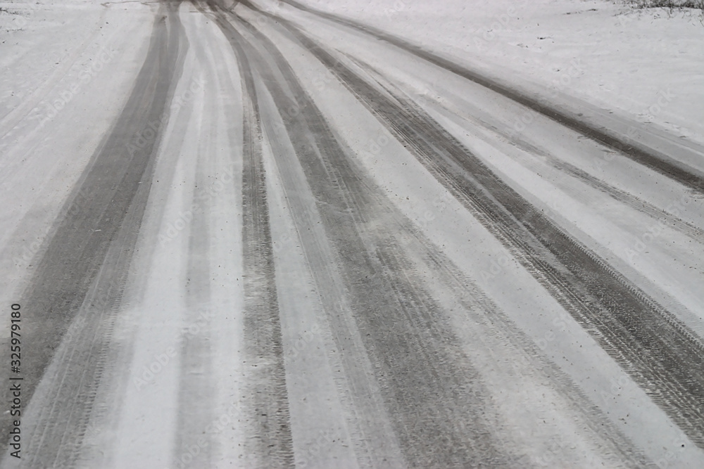 Naklejka premium car tracks on the road covered with fresh snow