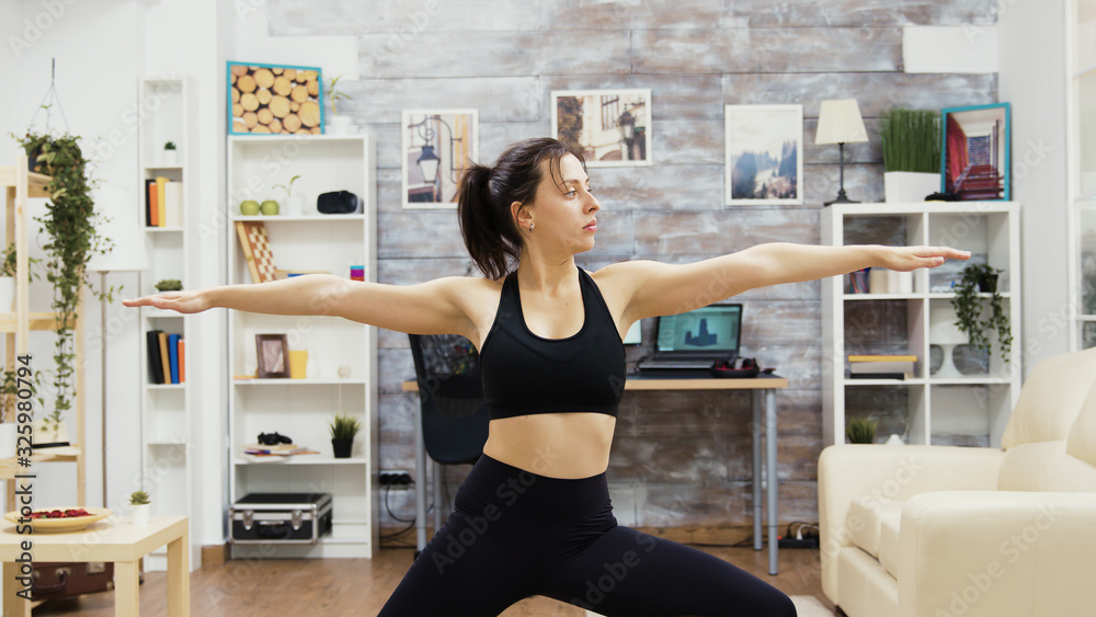 Young woman keeping her eyes closed standing in yoga pose