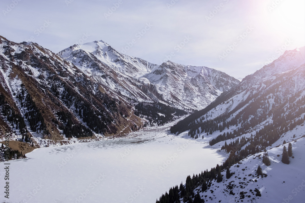 Beautiful mountains with frozen lake in sunny winter day. BAO or big almaty lake.