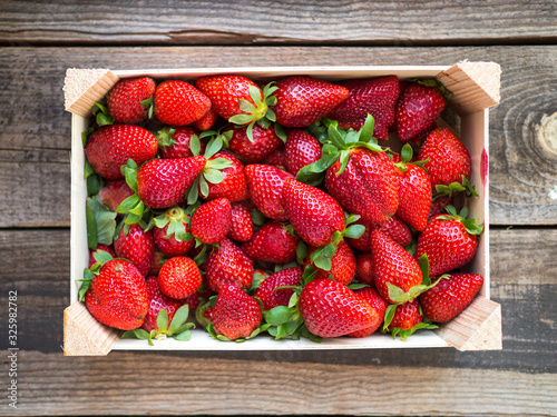 Wooden box with strawberries on a dark wooden table