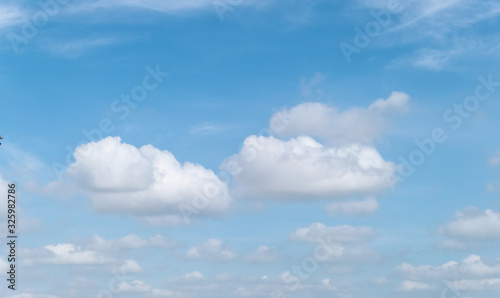 Blue sky with white soft clouds. Simple outdoor sky background.
