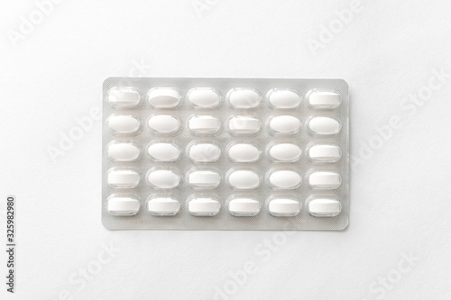 White pills tablets in package on a white background. Capsule pills in plastic pack.