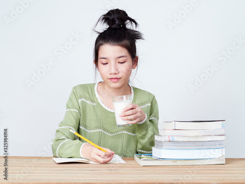 Students drink milk while doing homework.