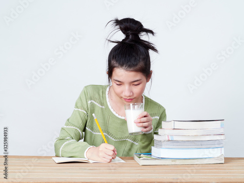 Students drink milk while doing homework.