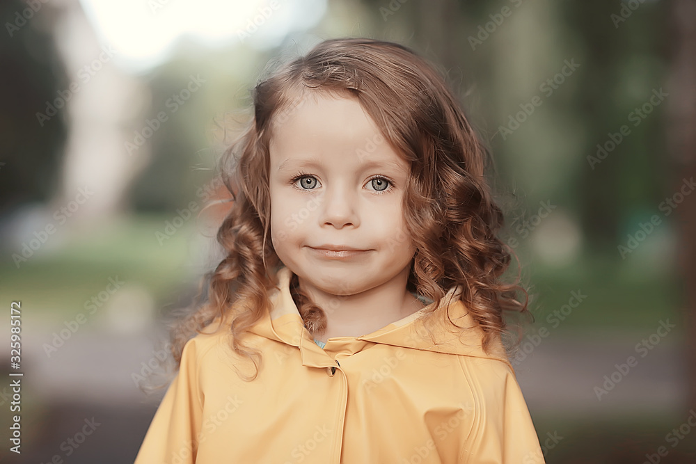 little girl in a yellow raincoat / portrait of a child in autumn clothes, a walk in the rain little girl in a yellow raincoat / portrait of a child in autumn clothes, a walk in the rain