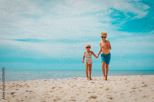 happy boy and girl running on beach